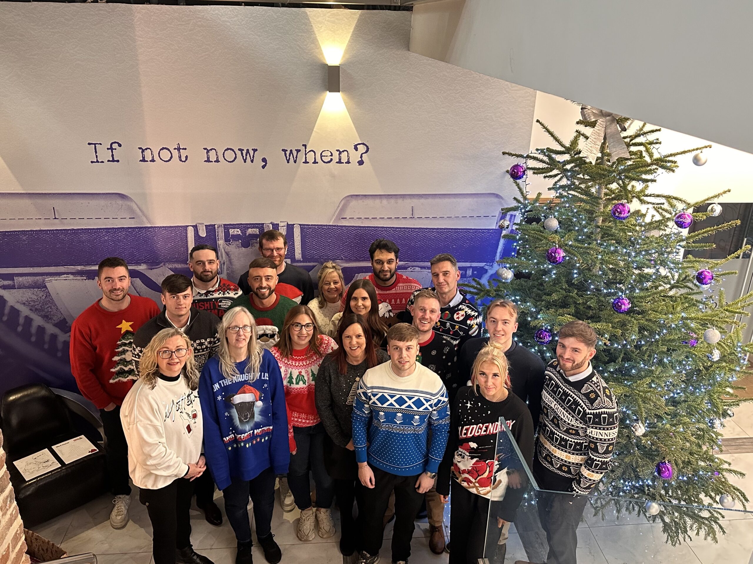 Ramsbottom team gathered round the Christmas tree wearing their festive jumpers for Save the Children