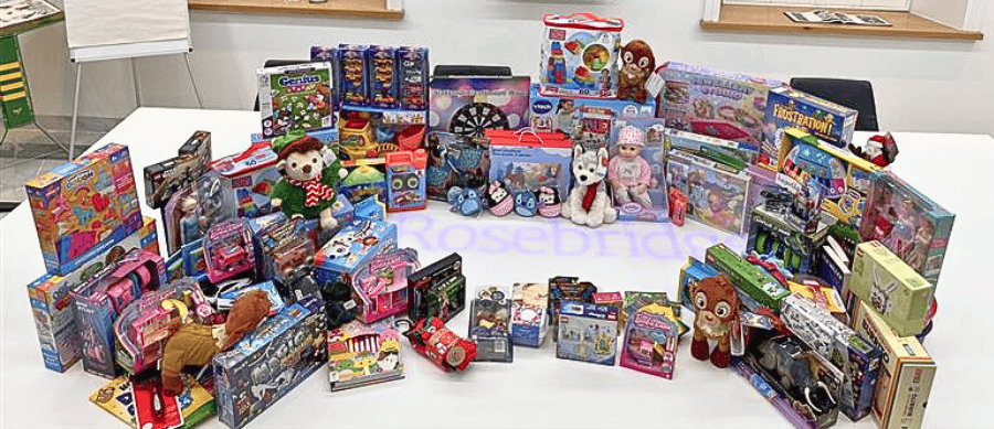 All the presents donated during Rosebridge's Mission Christmas gift drive displayed on a boardroom table at the Ramsbottom office
